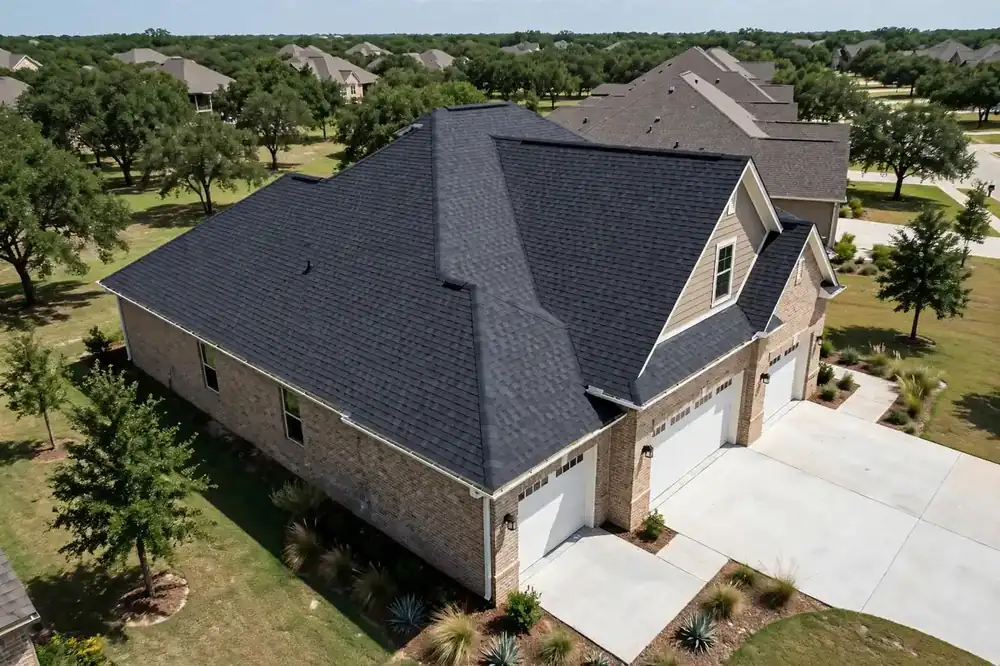 Aerial view of home with new asphalt shingle roof after emergency repair